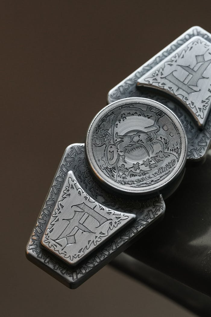 services-03 Close-up of a detailed metal accessory featuring intricate engraved designs on a neutral background.