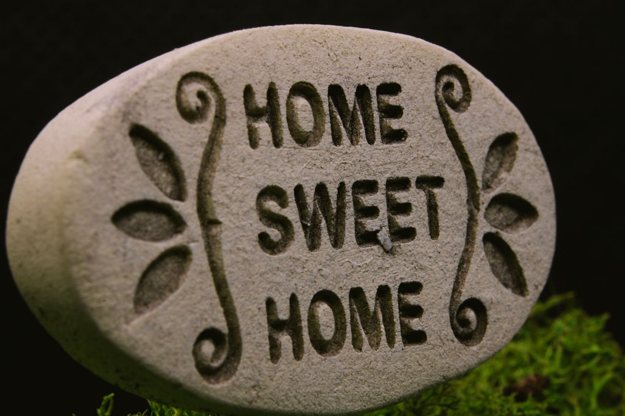 services-04 Close-up of a decorative stone engraved with 'Home Sweet Home' text, set against a natural background.