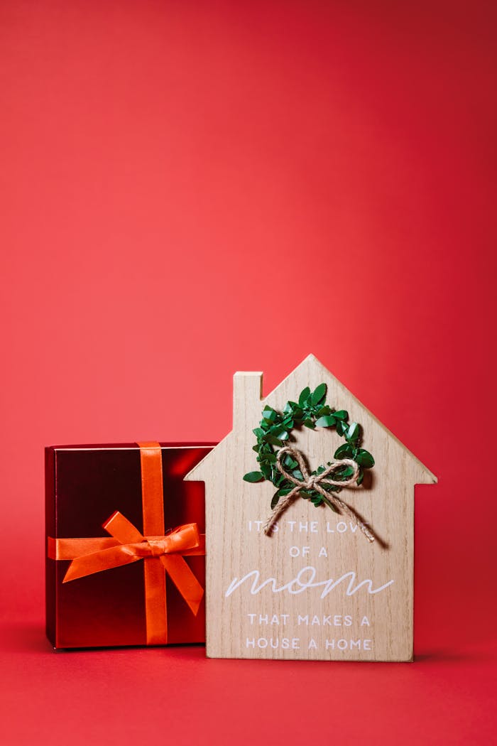 services-02 Wooden house sign and gift box on red background, perfect for Mother's Day gifting.